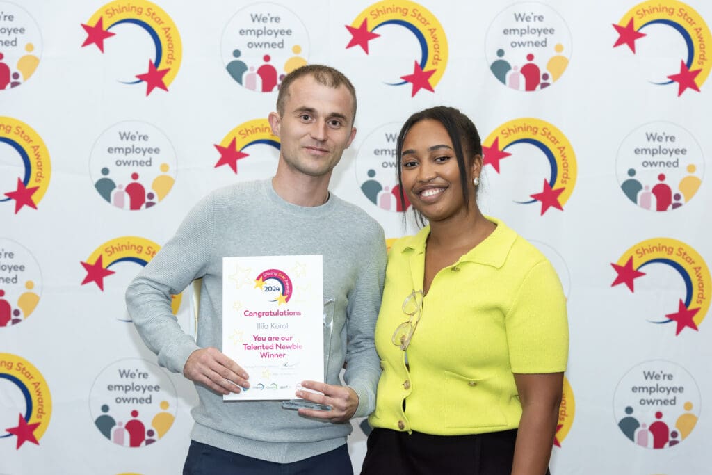 Man holding a certifcate and trophy standing next to woman